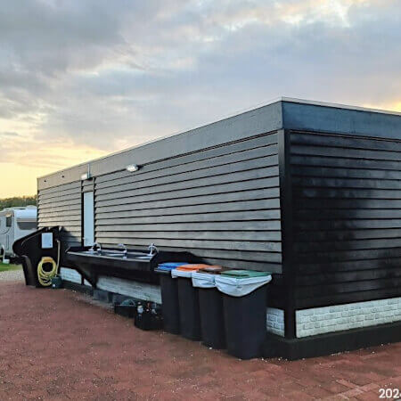 Foto: De serviceplek, netjes uit het zicht aan de achterkant van het sanitair gebouw