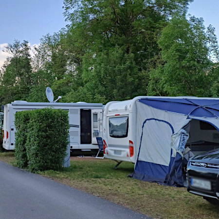 Foto: Auto's staan op de plaats naast de caravan, vouwwagen of tent