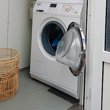 Aan de achterkant van het sanitair gebouw vind je de wasserette Foto: Aan de achterkant van het sanitair gebouw vind je de wasserette